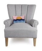 Pink Sky Coastal Sunset Hooked Wool Throw Pillow on an armchair, showing the throw pillow at room scale, 8x12 inch