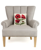 Poppies Hooked Wool Throw Pillow on an armchair, showing the throw pillow at room scale, 10x10 inch