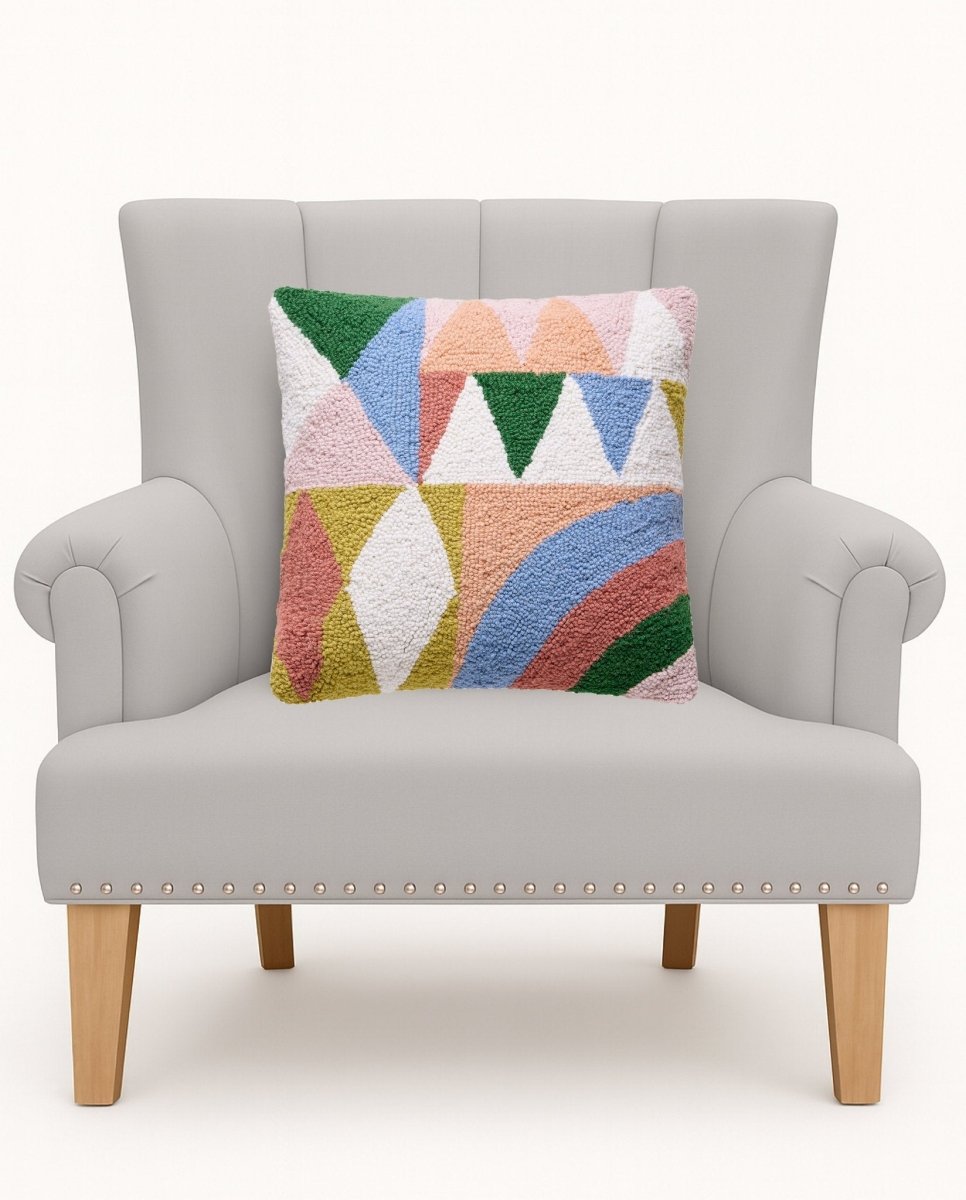 Rainbow Collage Hooked Wool Throw Pillow on an armchair, showing the throw pillow at room scale, 16x16 inch