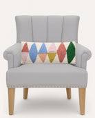 Rainbow Triangles Hooked Wool Throw Pillow on an armchair, showing the throw pillow at room scale, 8x20 inch