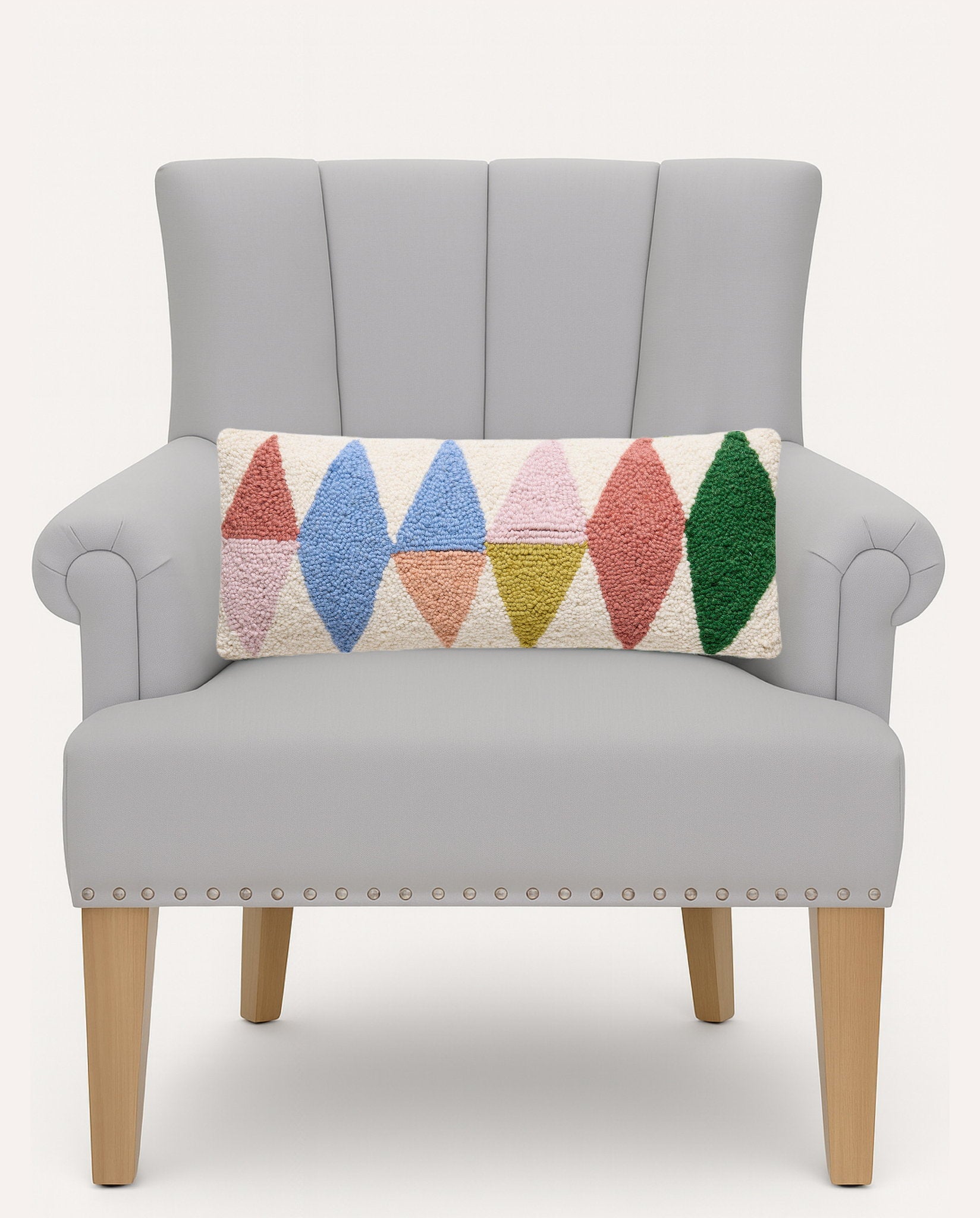 Rainbow Triangles Hooked Wool Throw Pillow on an armchair, showing the throw pillow at room scale, 8x20 inch