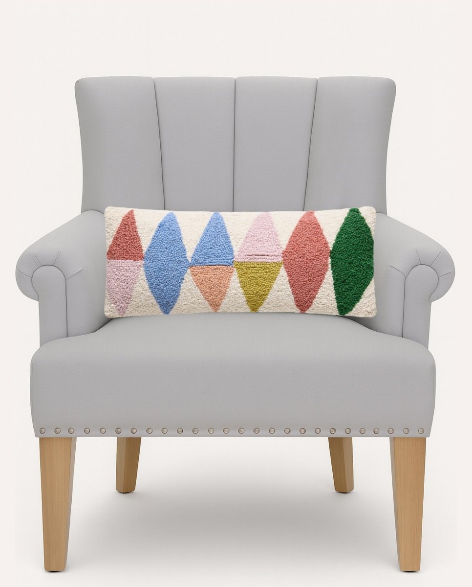 Rainbow Triangles Hooked Wool Throw Pillow on an armchair, showing the throw pillow at room scale, 8x20 inch
