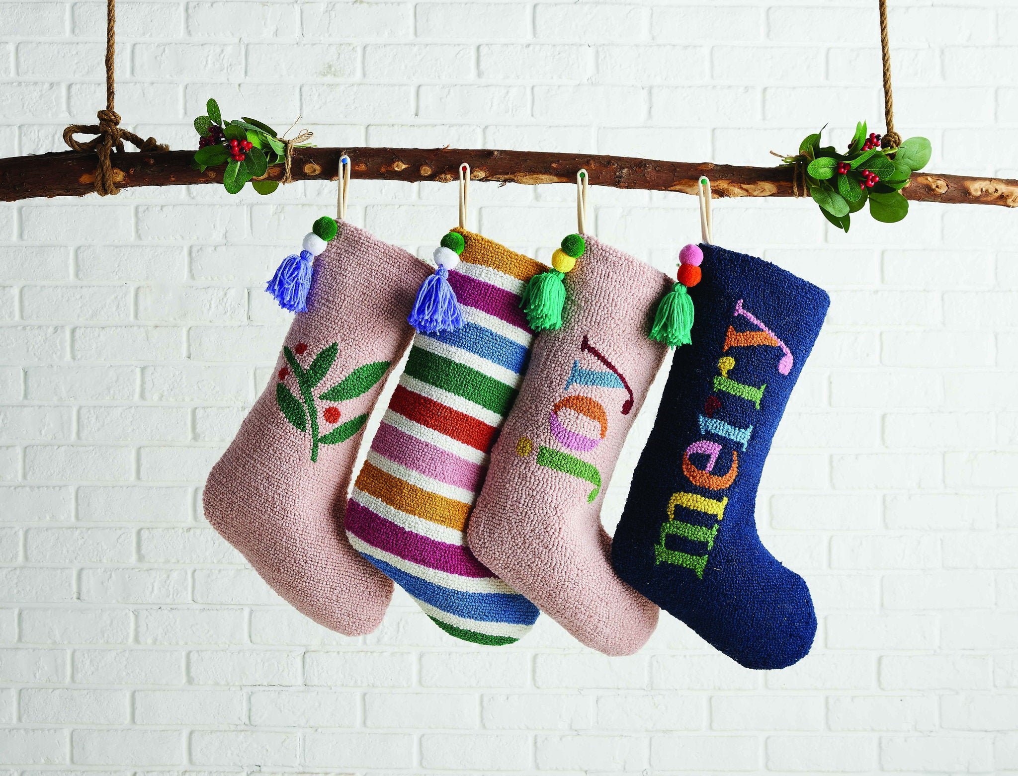 Rainbow with Pom Tassel Hooked Wool Christmas Stocking shown alongside other designs in the same collection, 12x20 inch