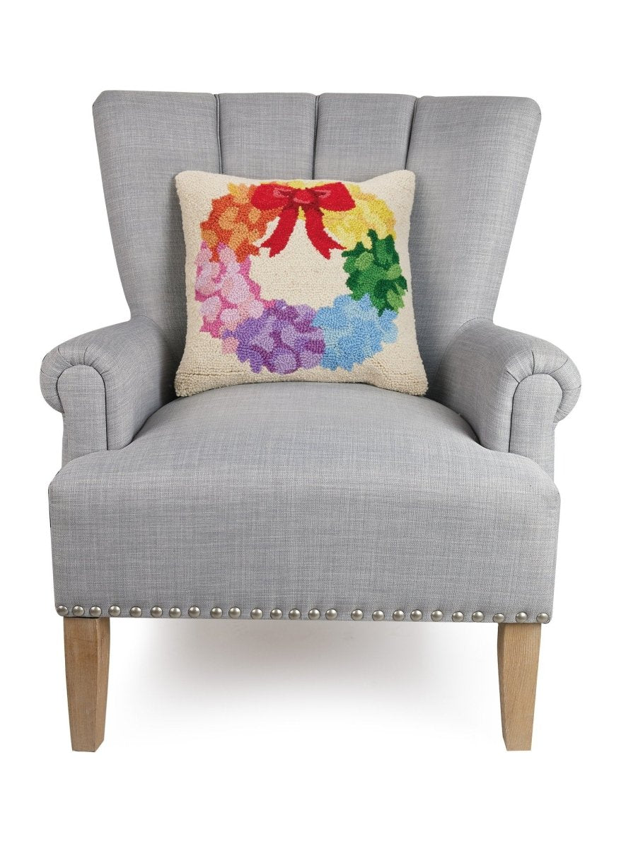 Rainbow Wreath Hooked Wool Christmas Throw Pillow on an armchair, showing the throw pillow at room scale, 16x16 inch