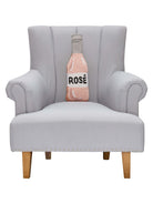 Rose Bottle Hooked Wool Throw Pillow on an armchair, showing the throw pillow at room scale, 6x18 inch