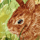 Closeup of Rustic Brown Thumper Rabbit Grass needlepoint throw pillow highlighting hand-stitched wool craftsmanship and fabric detail