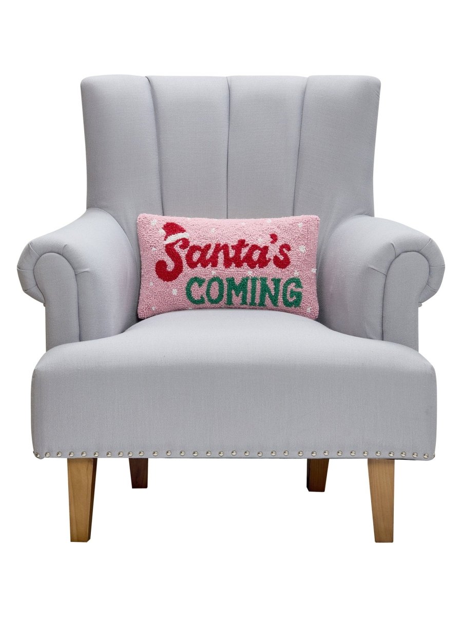 Santa's Coming Hooked Wool Christmas Throw Pillow on an armchair, showing the throw pillow at room scale, 9x16 inch