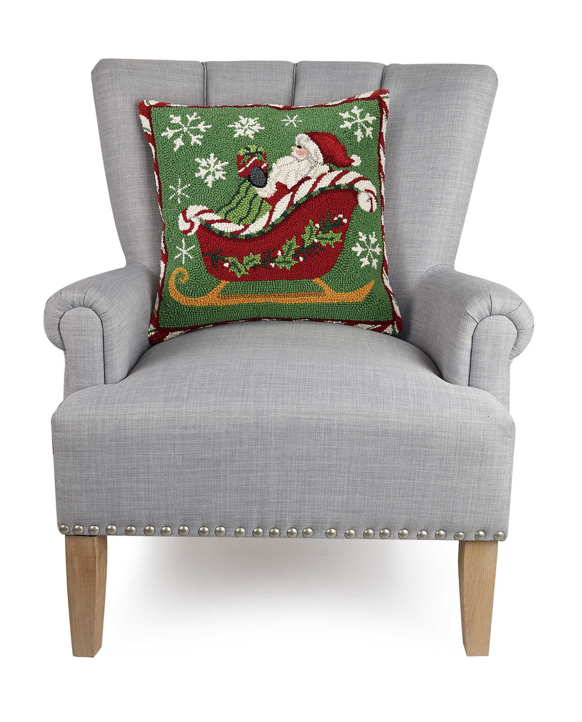 Santa Sleigh Hooked Wool Christmas Throw Pillow on an armchair, showing the throw pillow at room scale, 18x18 inch