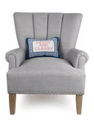 Sassy/Classy Embroidered Needlepoint Throw Pillow on an armchair, showing the throw pillow at room scale, 10x14 inch