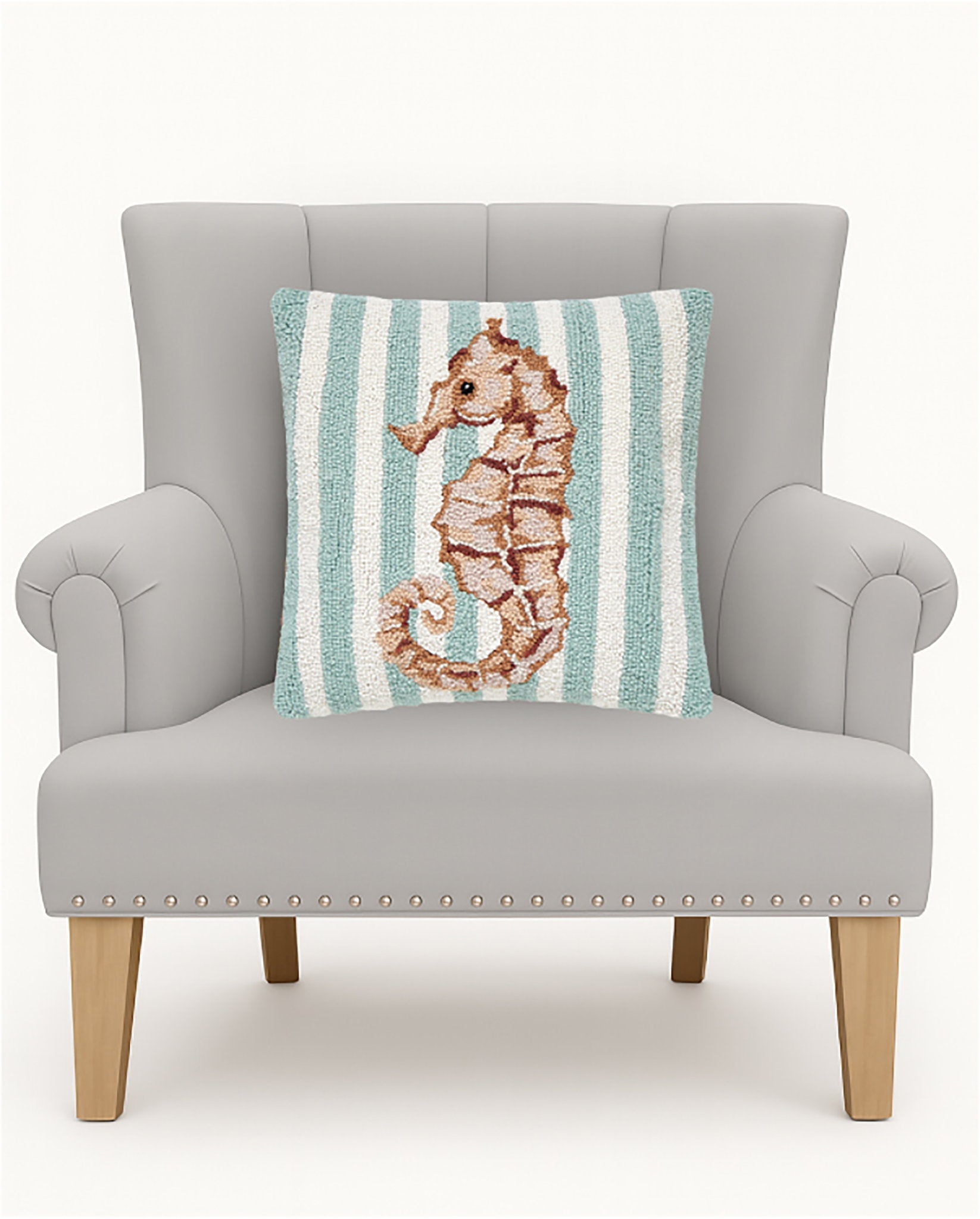 Seahorse Hooked Wool Throw Pillow on an armchair, showing the throw pillow at room scale, 16x16 inch