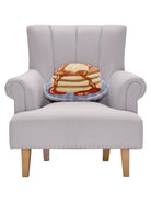 Shaped Pancakes Hooked Wool Throw Pillow on an armchair, showing the throw pillow at room scale, 12x18 inch