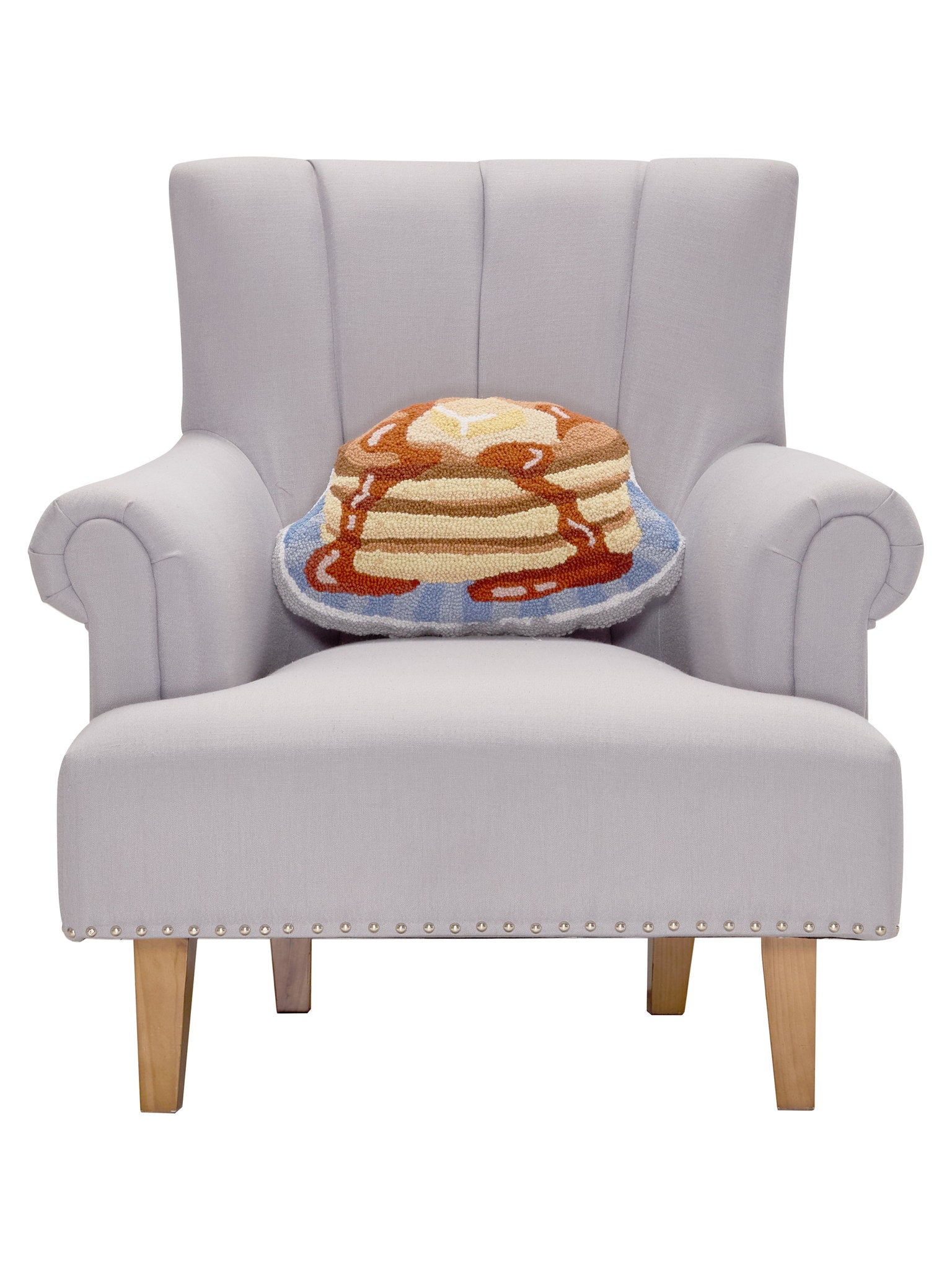 Shaped Pancakes Hooked Wool Throw Pillow on an armchair, showing the throw pillow at room scale, 12x18 inch