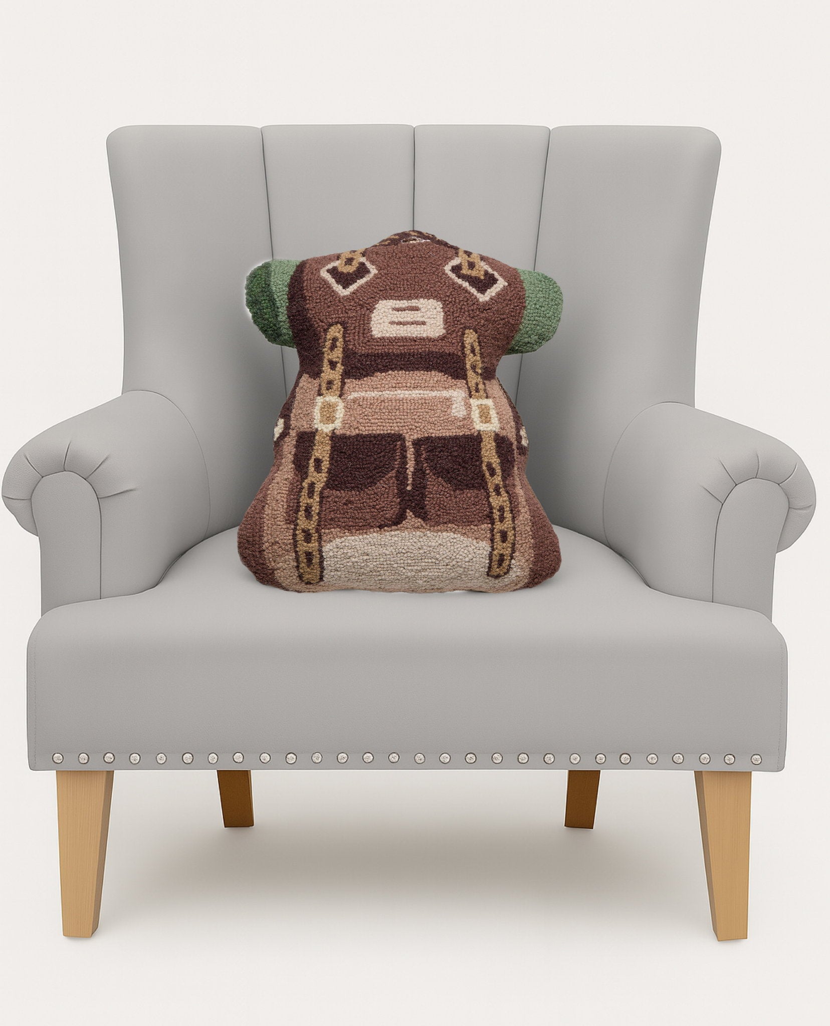 Shaped Trekking Hooked Wool Throw Pillow on an armchair, showing the throw pillow at room scale, 14x18 inch