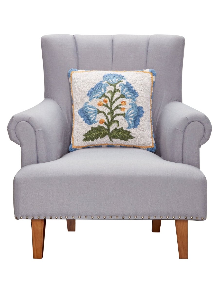 Single Blue Bloom Mughal Flower Hooked Wool Throw Pillow on an armchair, showing the throw pillow at room scale, 16x16 inch