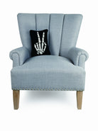 Skeleton Peace Hooked Wool Halloween Throw Pillow on an armchair, showing the throw pillow at room scale, 8x12 inch