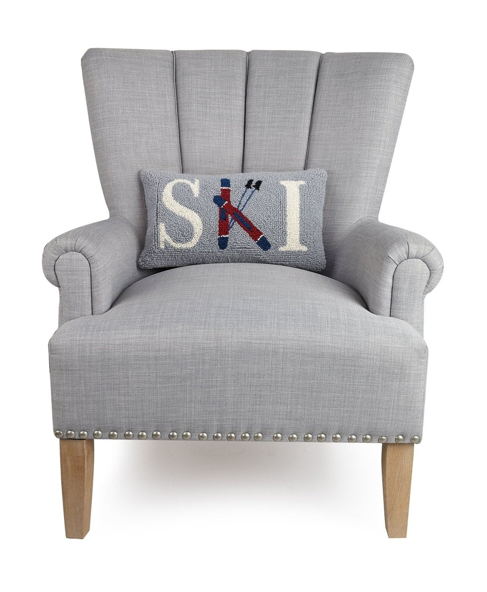 Ski Hooked Wool Christmas Throw Pillow on an armchair, showing the throw pillow at room scale, 9x16 inch