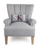 Ski Hooked Wool Christmas Throw Pillow on an armchair, showing the throw pillow at room scale, 9x16 inch