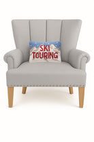Ski Touring Hooked Wool Christmas Throw Pillow on an armchair, showing the throw pillow at room scale, 8x12 inch