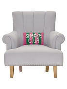 Snooze Club Hooked Wool Throw Pillow on an armchair, showing the throw pillow at room scale, 8x12 inch
