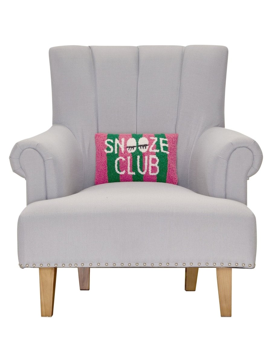 Snooze Club Hooked Wool Throw Pillow on an armchair, showing the throw pillow at room scale, 8x12 inch
