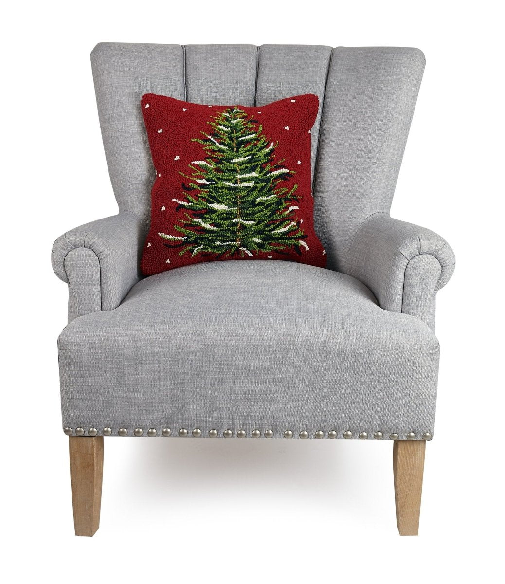 Snowy Evergreen Christmas Tree Hooked Wool Throw Pillow on an armchair, showing the throw pillow at room scale, 16x16 inch