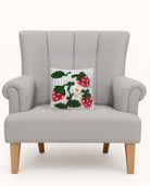 Strawberries Tufted Poly Hooked Throw Pillow on an armchair, showing the throw pillow at room scale, 10x10 inch