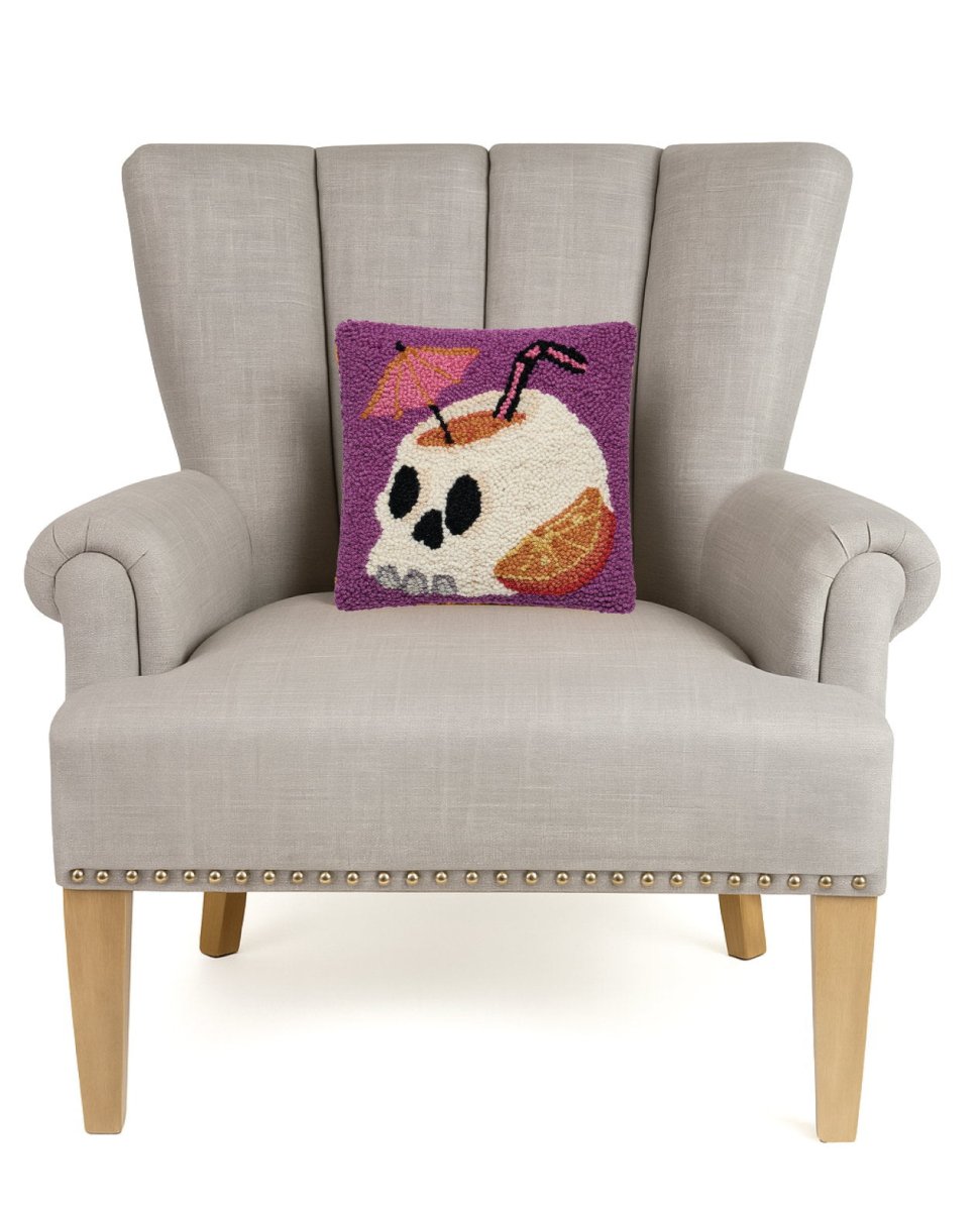 Summerween Skull Hooked Wool Halloween Throw Pillow on an armchair, showing the throw pillow at room scale, 10x10 inch