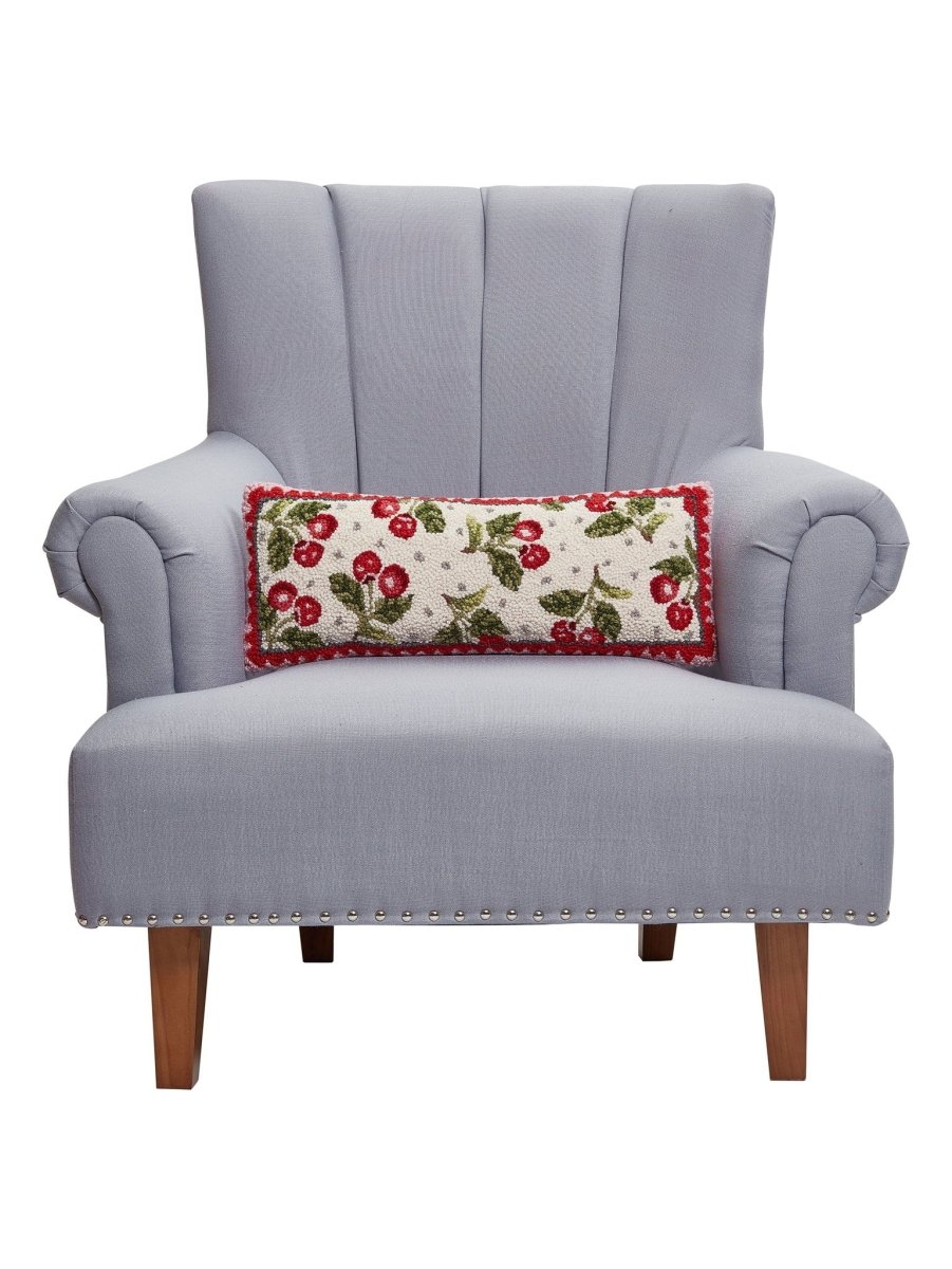 Sweet Cherry Hooked Wool Throw Pillow on an armchair, showing the throw pillow at room scale, 8x20 inch