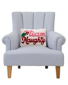 Team Naughty Hooked Wool Christmas Throw Pillow on an armchair, showing the throw pillow at room scale, 8x12 inch