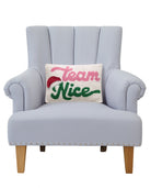 Team Nice Hooked Wool Christmas Throw Pillow on an armchair, showing the throw pillow at room scale, 8x12 inch