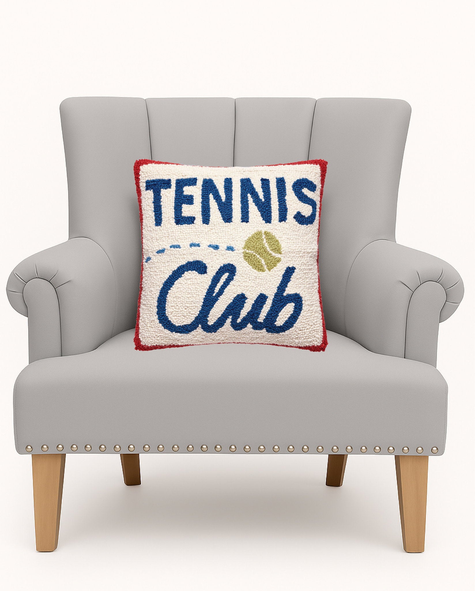 Tennis Club Hooked Wool Throw Pillow on an armchair, showing the throw pillow at room scale, 14x14 inch