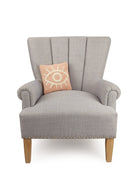 The Eye Hooked Wool Throw Pillow on an armchair, showing the throw pillow at room scale, 10x10 inch