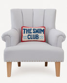 The Swim Club Hooked Wool Throw Pillow on an armchair, showing the throw pillow at room scale, 8x12 inch