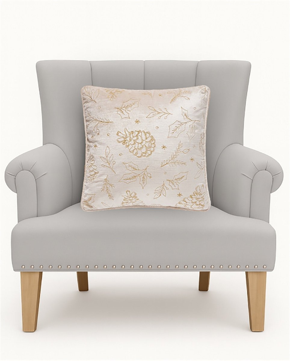 Tossed Foliage Champagne Velvet Embroidered Christmas Throw Pillow on an armchair, showing the throw pillow at room scale, 16x16 inch
