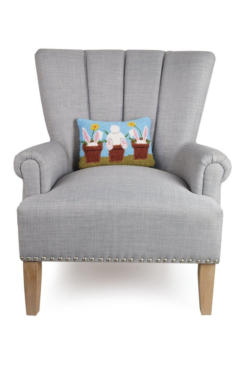 Vase Rabbits Hooked Wool Easter Throw Pillow on an armchair, showing the throw pillow at room scale, 8x12 inch