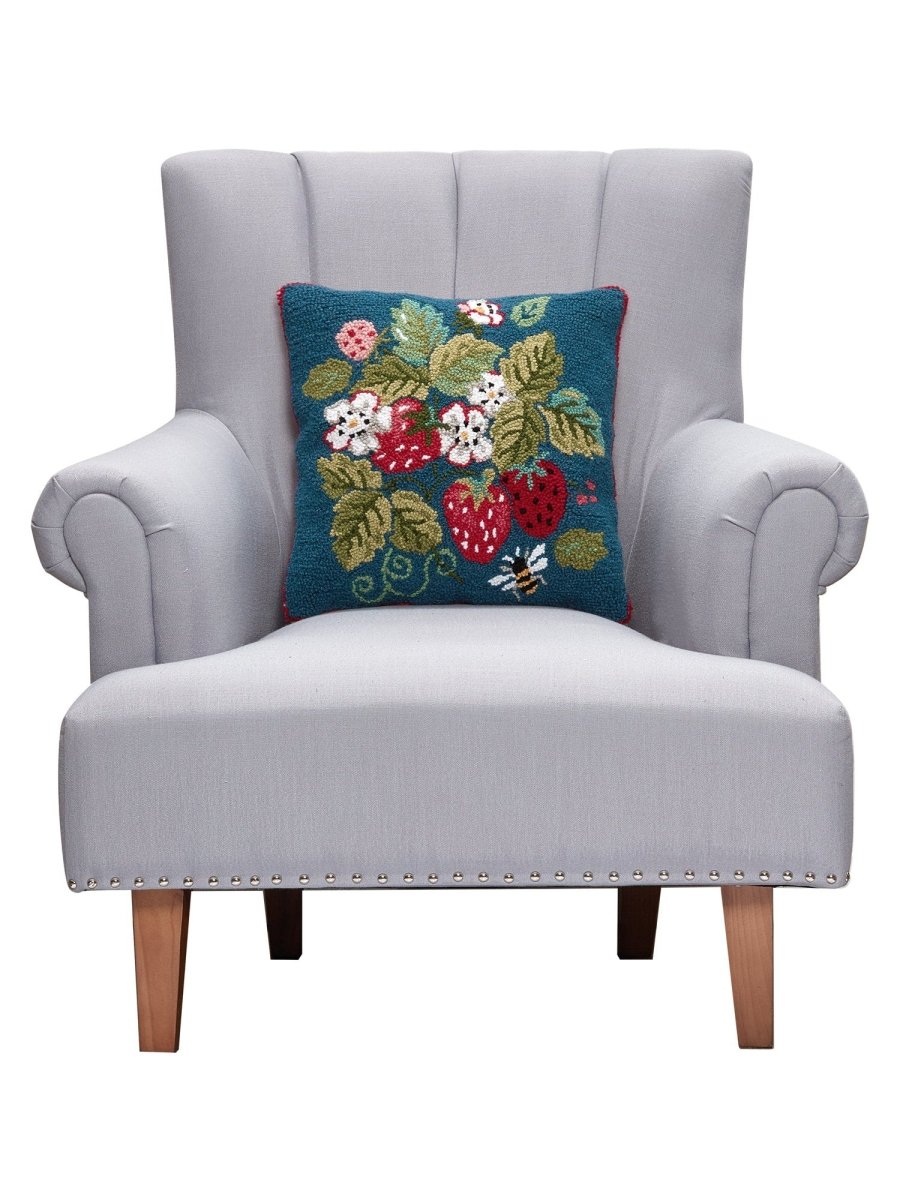 Vintage Strawberries Hooked Wool Throw Pillow on an armchair, showing the throw pillow at room scale, 16x16 inch