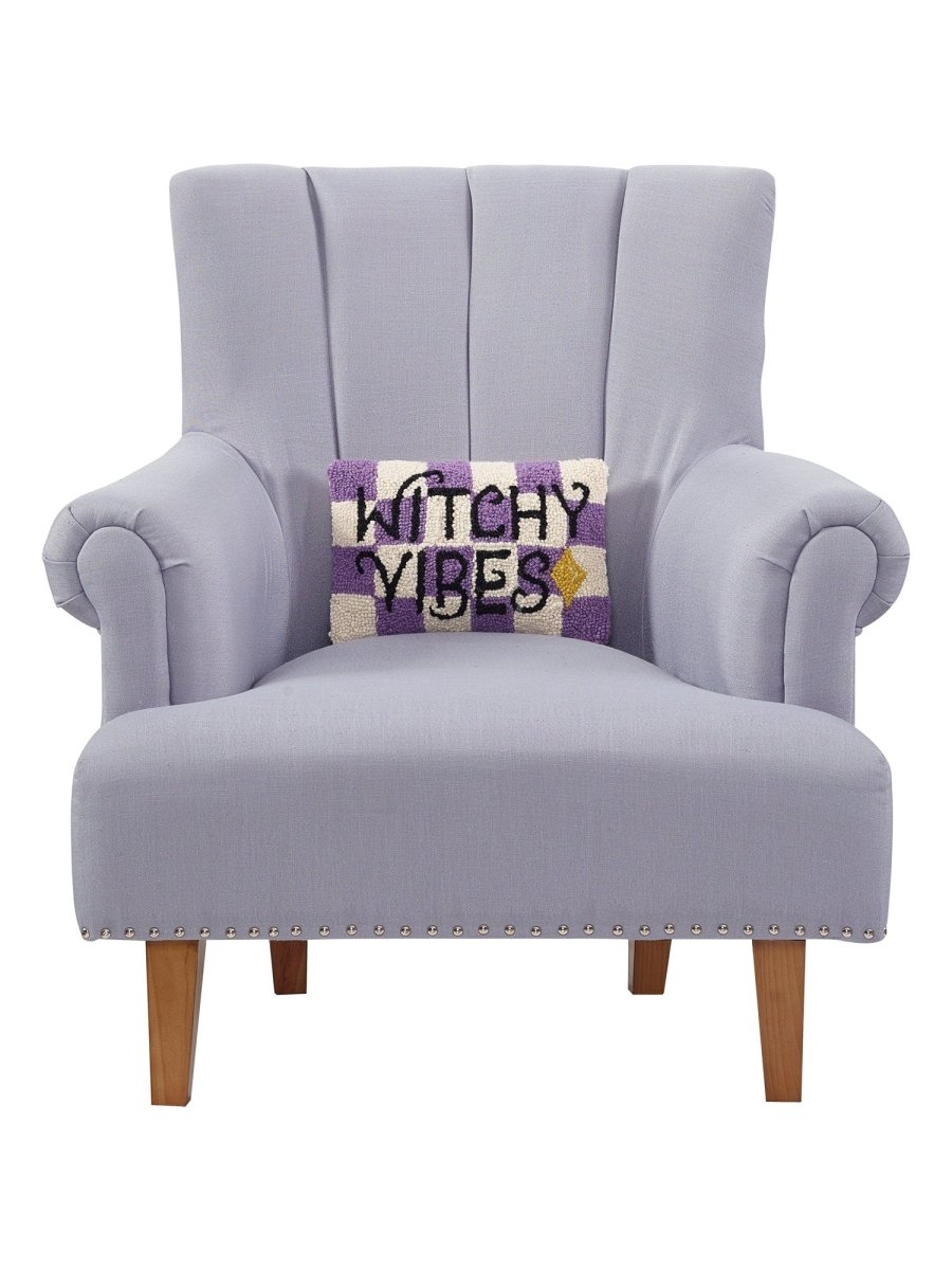 Witchy Vibes Hooked Wool Halloween Throw Pillow on an armchair, showing the throw pillow at room scale, 8x12 inch