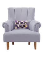 Witchy Vibes Hooked Wool Halloween Throw Pillow on an armchair, showing the throw pillow at room scale, 8x12 inch