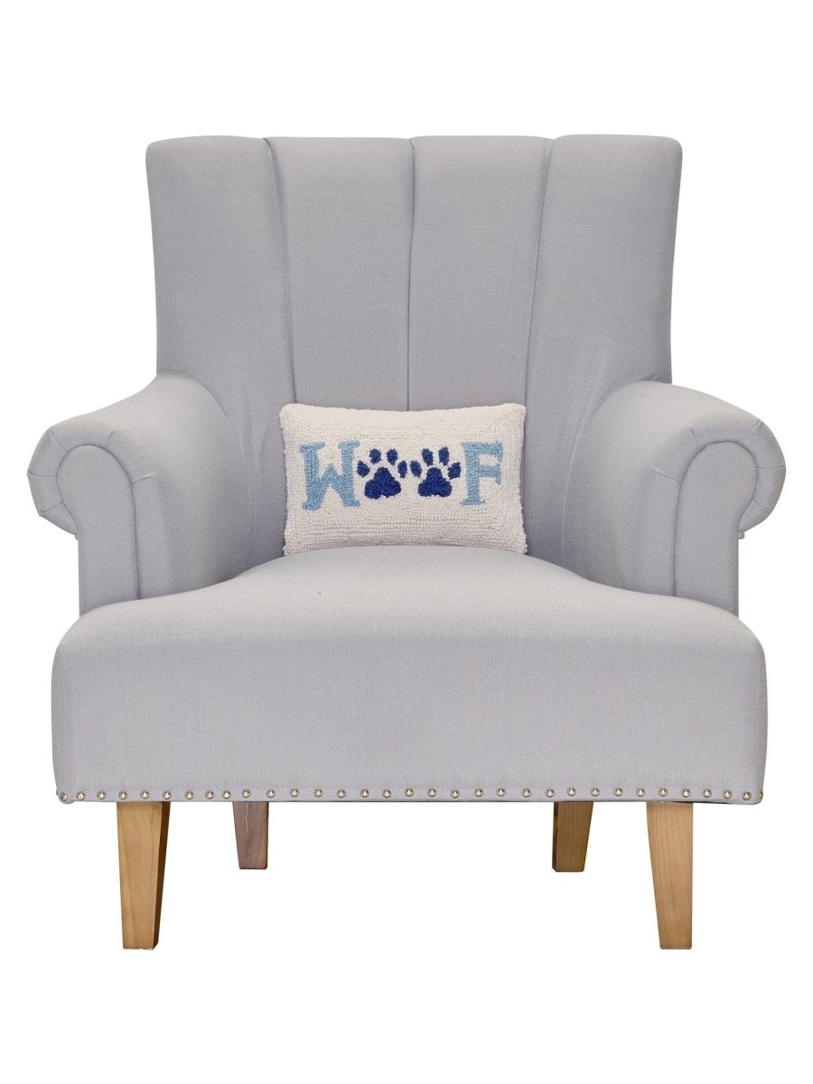Woof Hooked Wool Throw Pillow on an armchair, showing the throw pillow at room scale, 8x12 inch