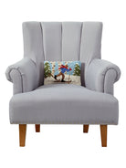 X-Country Skier Hooked Wool Christmas Throw Pillow on an armchair, showing the throw pillow at room scale, 8x12 inch